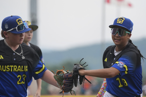 Australia's Monica Arcuri, right, and Braxton Black, left, run off the field during the fourth inning of a baseball game at the Little League World Series against Canada, Sunday, Aug. 17, 2025, in South Williamsport, Pa. (AP Photo/Caleb Craig)