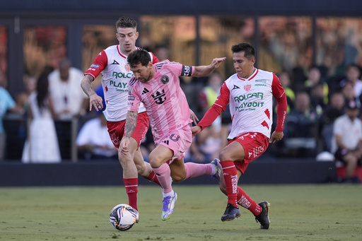 Inter Miami forward Lionel Messi, center, charges through Necaxa forward Raul Sanchez, left, and midfielder Jose Rodriguez, during the first half of a Leagues Cup soccer match, Saturday, Aug. 2, 2025, in Fort Lauderdale, Fla. (AP Photo/Rebecca Blackwell)