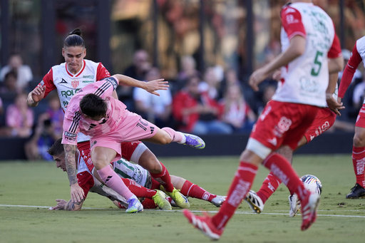 Inter Miami forward Lionel Messi (10) takes a tumble in a clash with Necaxa defenders Alexis Pena, top, and Cristian Calderon, bottom, during the first half of a Leagues Cup soccer match, Saturday, Aug. 2, 2025, in Fort Lauderdale, Fla. (AP Photo/Rebecca Blackwell)