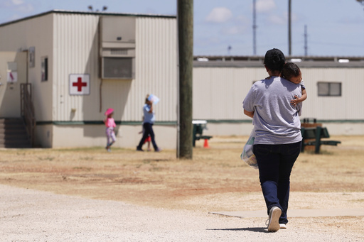 FILE - Immigrants seeking asylum walk through the ICE South Texas Family Residential Center in Dilley, Texas, on Aug. 23, 2019. (AP Photo/Eric Gay, File)