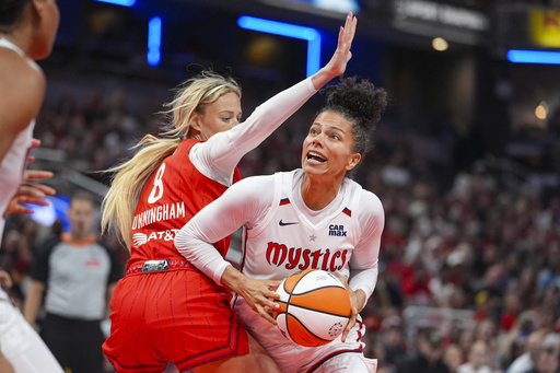 Washington Mystics forward Alysha Clark (32) looks to shoot around Indiana Fever guard Sophie Cunningham (8) in the second half of a WNBA basketball game in Indianapolis, Friday, Aug. 15, 2025. (AP Photo/Michael Conroy)