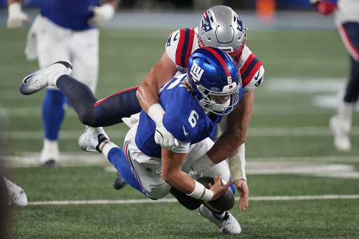 New York Giants quarterback Jaxson Dart (6) is tackled by New England Patriots linebacker Jack Gibbens (51) during the first quarter of an NFL football game, Thursday, Aug. 21, 2025, in East Rutherford, N.J. (AP Photo/Frank Franklin II)