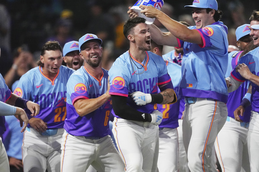 Colorado Rockies' Brenton Doyle, third from left, celebrates after hitting a two-run, walkoff home run with teammates, from left, Jordan Beck, Kyle Farmer and Michael Toglia in the ninth inning of a baseball game against the Pittsburgh Pirates Friday, Aug. 1, 2025, in Denver. (AP Photo/David Zalubowski)