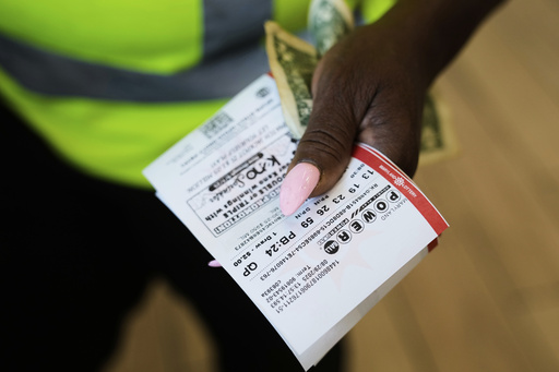 Roslyn Jefferson holds her Powerball lottery tickets ahead of Saturday's Powerball drawing offering of $1 billion, Friday, Aug. 29, 2025, in Baltimore. (AP Photo/Stephanie Scarbrough)