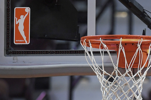 FILE - The WNBA logo is seen near a hoop before an WNBA basketball game at Mohegan Sun Arena, Tuesday, May 14, 2019, in Uncasville, Conn. (AP Photo/Jessica Hill, File)