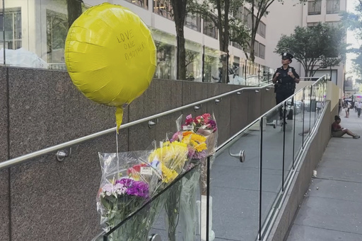 A police officer stands by a make shift memorial outside scene of Monday's deadly shooting on Tuesday, July 29, 2025 in New York. (AP Photo/Ted Shaffrey)