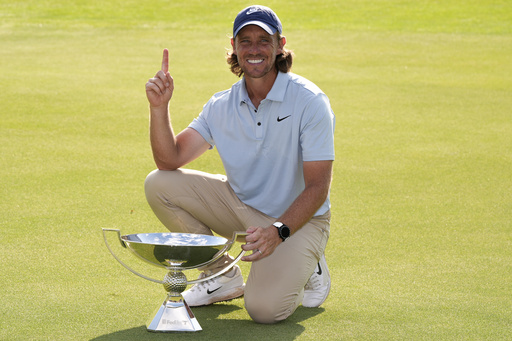 Tommy Fleetwood, of England, holds the championship trophy after the final round of the Tour Championship golf tournament, Sunday, Aug. 24, 2025, in Atlanta. (AP Photo/Mike Stewart)