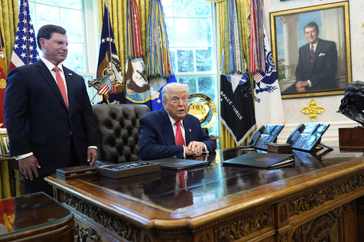Social Security Commissioner Frank Bisignano, left, listens as President Donald Trump speaks during event in the Oval Office to mark the 90th anniversary of the Social Security Act, Thursday, Aug. 14, 2025, in Washington. (AP Photo/Alex Brandon)