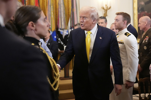 President Donald Trump greets attendees as he departs an event to mark National Purple Heart Day in the East Room of the White House, Thursday, Aug. 7, 2025, in Washington. (AP Photo/Mark Schiefelbein)