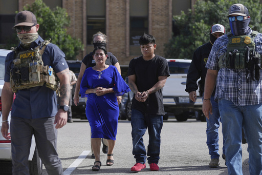 FILE - Federal agents escort a family to a transport bus after they were detained following an appearance at immigration court, July 22, 2025, in San Antonio, Texas. (AP Photo/Eric Gay, File)