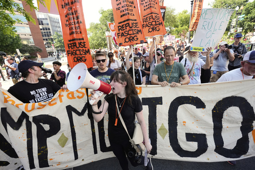 Activists carrying signs march to the White House to protest President Donald Trump's federal takeover of policing of the District of Columbia, Saturday, Aug. 16, 2025, in Washington. (AP Photo/Alex Brandon)
