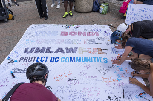 Activists with Free DC work on a banner as they gather outside Washington Metropolitan Police Department headquarters in Washington, Friday, Aug. 15, 2025. (AP Photo/Alex Brandon)