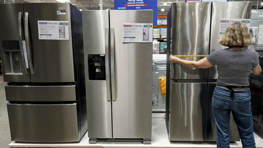 A woman measures a new appliance at a store in Kennesaw, Ga., on Thursday, Aug. 14, 2025. (AP Photo/Mike Stewart)
