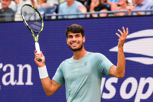 Carlos Alcaraz, of Spain, gestures to fans during a mixed doubles match at the U.S. Open tennis championships, Tuesday, Aug. 19, 2025, in New York. (AP Photo/Yuki Iwamura)