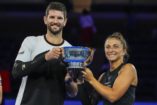 Andrea Vavassori, left, of Italy, and Sara Errani, of Italy, hold up the championship trophy after defeating Iga Swiatek, of Poland, and Casper Ruud, of Norway, in the mixed doubles final at the U.S. Open tennis championships, Wednesday, Aug. 20, 2025, in New York. (AP Photo/Yuki Iwamura)