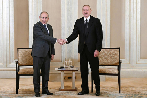 In this photo provided by the Azerbaijan's Presidential Press Office on Thursday, July 10, 2025, Azerbaijani President Ilham Aliyev, right, and Prime Minister of Armenia Nikol Pashinyan pose for a photo prior to their talks in Abu Dhabi, United Arab Emirates. (Azerbaijani Presidential Press Office via AP)
