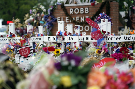 FILE - Crosses are surrounded by flowers and other mementos at a memorial, June 9, 2022, for the victims of a shooting at Robb Elementary School in Uvalde, Texas. (AP Photo/Eric Gay, File)