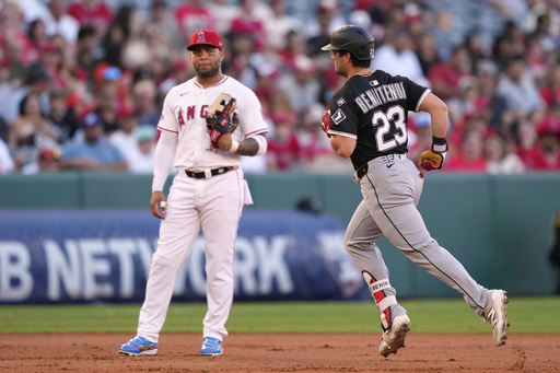 Chicago White Sox's Andrew Benintendi, right, runs by Los Angeles Angels third baseman Yoan Moncada after hitting a solo home run during the second inning of a baseball game Friday, Aug. 1, 2025, in Anaheim, Calif. (AP Photo/Mark J. Terrill)