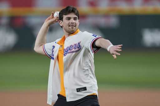 IndyCar driver Pato O'Ward, of Mexico throws out the ceremonial first pitch before a baseball game between the New York Yankees and Texas Rangers Wednesday, Aug. 6, 2025, in Arlington, Texas. (AP Photo/Tony Gutierrez)