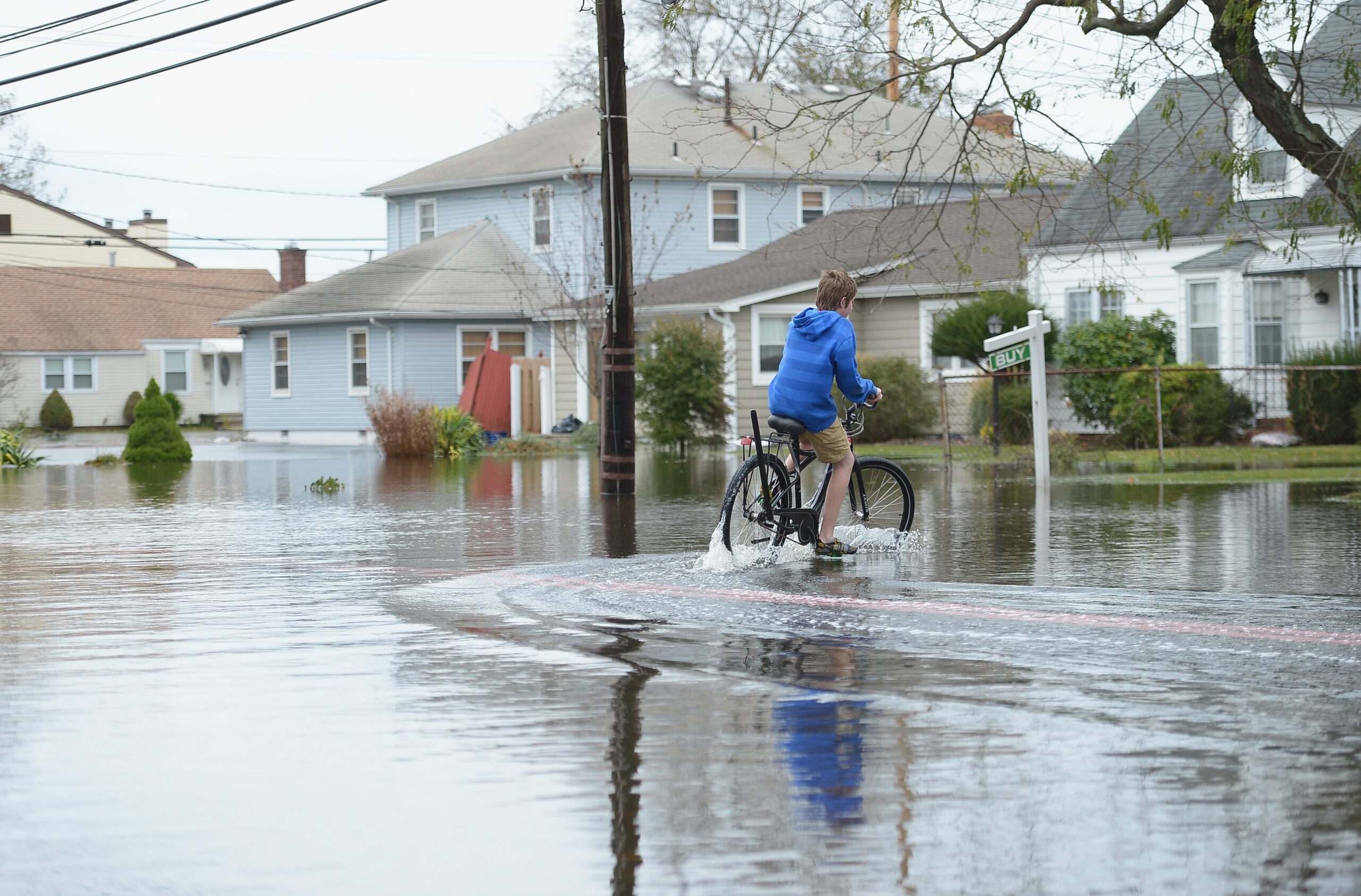 A young boy rides a bike through Hurricane Sandy floodwaters on Oct. 30, 2012 in Point Pleasant Beach, New Jersey. (Photo by Michael Loccisano/Getty Images)