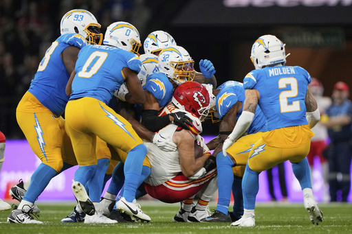 Kansas City Chiefs tight end Travis Kelce is tackled by the Los Angeles Chargers during the first half of an NFL football game, Friday, Sept. 5, 2025, in Sao Paulo. (AP Photo/Doug Benc)