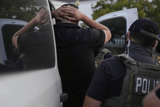 U.S. Immigration and Customs Enforcement agents make an arrest during an early morning operation in Park Ridge, Ill., Friday, Sept. 19, 2025. (AP Photo/Erin Hooley)