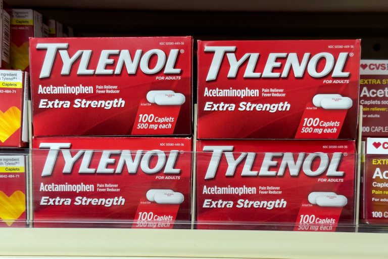 Boxes of Tylenol pain reliever on shelves in a pharmacy