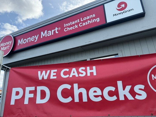 A sign advertising the cashing of Alaska Permanent Fund Dividend, or PFD, checks hangs outside a business in Anchorage, Alaska, Tuesday, Sept. 23, 2025. (AP Photo/Mark Thiessen)