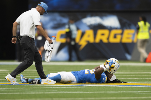 Los Angeles Chargers running back Najee Harris, right, lays on the ground after getting injured during an NFL football game against the Denver Broncos, Sunday, Sept. 21, 2025, in Inglewood, Calif. (AP Photo/Kyusung Gong)