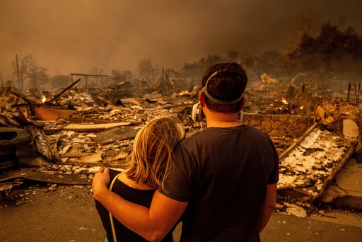 FILE - Megan Mantia, left, and her boyfriend Thomas, return to Mantia's fire-damaged home after the Eaton Fire swept through, Wednesday, Jan. 8, 2025 in Altadena, Calif. (AP Photo/Ethan Swope, File)