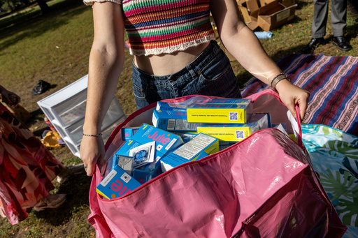 A DePaul University student carries a bag of contraceptive supplies at Oz Park in Chicago on Sunday, Sept. 28, 2025. (AP Photo/Heidi Zeiger)
