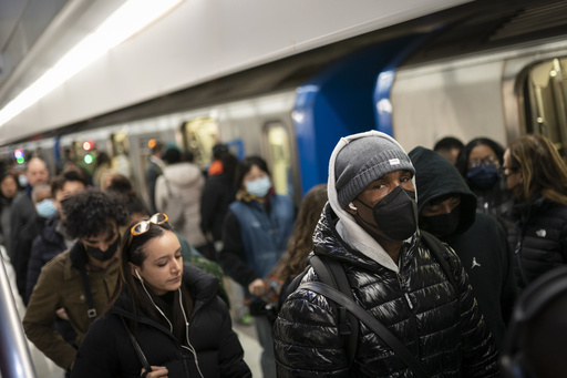 FILE - Mass transit riders commute in the financial district of lower Manhattan, Tuesday, April 19, 2022, in New York. (AP Photo/John Minchillo, File)