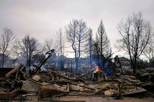 FILE - A fire burns in a home destroyed by the Marshall Wildfire in Louisville, Colo., Dec. 31, 2021. (AP Photo/Jack Dempsey, File)