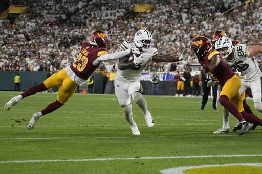 Green Bay Packers running back Josh Jacobs runs with the ball as Washington Commanders cornerback Trey Amos (23) defends during the second half of an NFL football game Thursday, Sept. 11, 2025, in Green Bay, Wis. (AP Photo/Morry Gash)