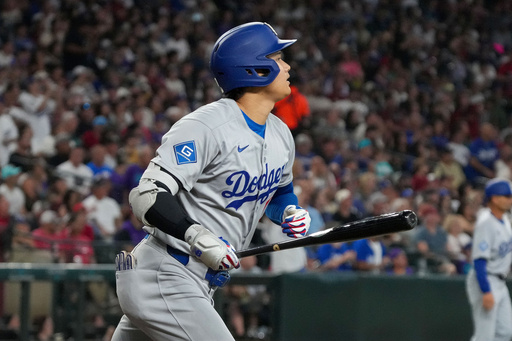 Los Angeles Dodgers' Shohei Ohtani watches his home run during the fourth inning of a baseball game against the Arizona Diamondbacks, Thursday, Sept. 25, 2025, in Phoenix. (AP Photo/Darryl Webb)