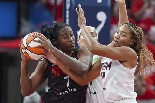 Indiana Fever forward Aliyah Boston (7) get tied up with Atlanta Dream forward Naz Hillmon (0) in the first half of a WNBA basketball playoff game in Indianapolis, Tuesday, Sept. 16, 2025. (AP Photo/Michael Conroy)