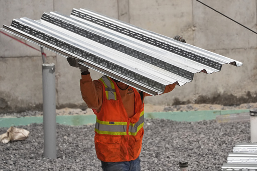 FILE - A construction worker carries steel decking at the site of a construction of a housing project, Thursday, July 31, 2025, in Portland, Maine. (AP Photo/Robert F. Bukaty, File)