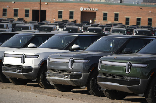 FILE - A long line of unsold 2024 R1S electric utility vehicles sits at a Rivian service center Nov. 26, 2024, in east Denver. (AP Photo/David Zalubowski, File)