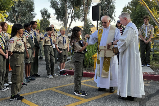 Scout Troop 228 participates in the U.S. flag retirement ceremony for Saint Kateri Tekakwitha Church during the annual Patriots Day observance at the church in Santa Clarita, Calif., on Thursday, Sept. 11, 2025. (AP Photo/Krysta Fauria)