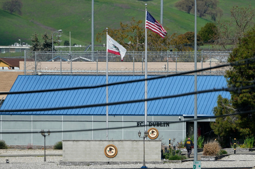 FILE - An official walks toward an entrance to the Federal Correctional Institution in Dublin, Calif., March 11, 2024. (AP Photo/Jeff Chiu, File)