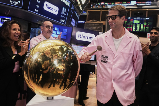 Klarna CEO Sebastian Siemiatkowski, right, rings a ceremonial bell as his company's IPO begins trading on the floor of the New York Stock Exchange, Wednesday, Sept. 10, 2025. NYSE President Lynn Martin applauds at left. (AP Photo/Richard Drew)