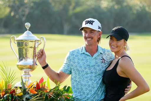FILE - Jake Knapp, of the United States, and his girlfriend Makena White pose with his trophy during the award ceremony after winning the Mexico Open golf tournament in Puerto Vallarta, Mexico, Sunday, Feb. 25, 2024. (AP Photo/Fernando Llano, File)