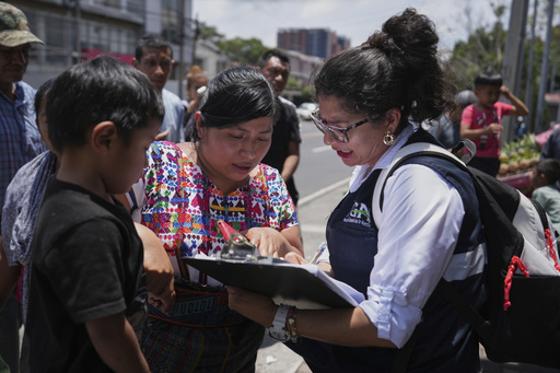 A relative of an unaccompanied minor deported from the United States reviews the list of those deported outside La Aurora International Airport, in Guatemala City, Sunday, Aug. 31, 2025. (AP Photo/Moises Castillo)