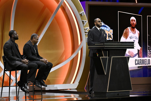 Carmelo Anthony, right, speaks During his enshrinement in the Basketball Hall of Fame as Dwyane Wade, left, and Allen Iverson listen, Saturday, Sept. 6, 2025, in Springfield, Mass. (AP Photo/Jessica Hill)