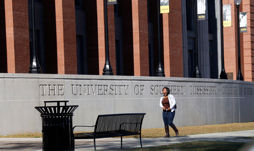 FILE - A student walks across the University of Southern Mississippi School of Business in Hattiesburg, Miss., Nov. 21, 2016. (AP Photo/Rogelio V. Solis, File)