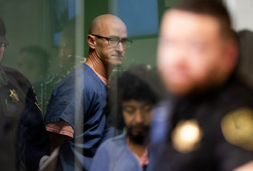 FILE - Joseph David Emerson, back, appears in Multnomah County Circuit Court for an indictment hearing in Portland, Ore., on Dec. 7, 2023. (Dave Killen/The Oregonian via AP, Pool, File)