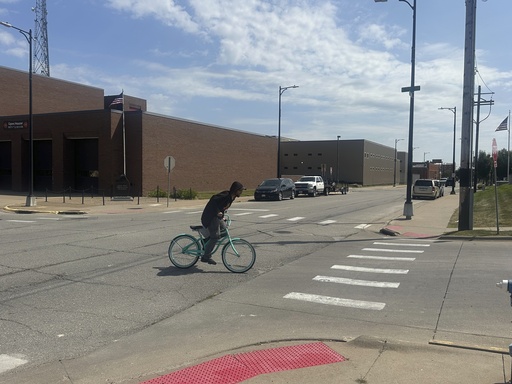 A cyclist crosses an intersection, on Monday, Sept. 8, 2025, where witnesses found Felipe de Jesus Hernandez Marcelo covered in blood after he was shot on June 21, in Muscatine, Iowa. (AP Photo/Ryan J. Foley)
