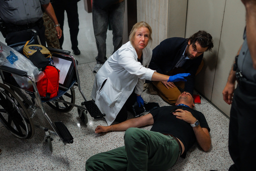 Journalist L. Vural Elibol receives medical assistance after being shoved by federal agents in immigration court on Tuesday, Sept. 30, 2025, in New York. (AP Photo/Olga Fedorova)