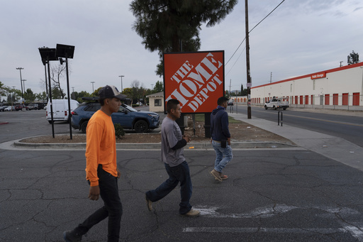 Workers walk toward a food vendor past a Home Depot sign in the Van Nuys section of Los Angeles, Aug. 28, 2025. (AP Photo/Jae C. Hong)
