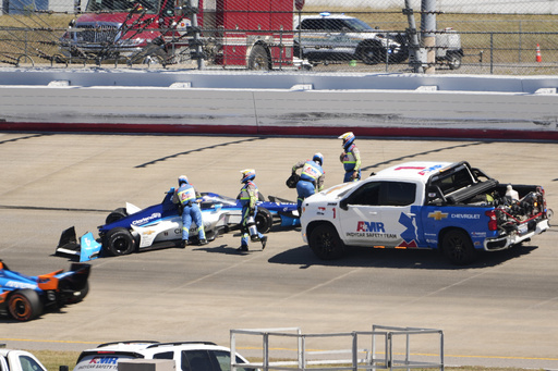 David Malukas (4) is helped by track personnel after his crash during an IndyCar auto race Sunday, Aug. 31, 2025, at Nashville Superspeedway in Lebanon, Tenn. (AP Photo/George Walker IV)